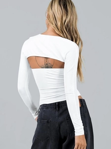 Detail of white long sleeve backless crop top with cross straps and cut-out design