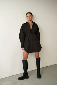 Vue complète d'une robe chemise noire évasée à manches longues avec des bottes hautes
