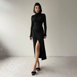 Detail of elegant black midi dress featuring a ruched waist and high slit design