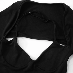 Detail of black knit dress featuring a scoop neckline and adjustable silver buckles
