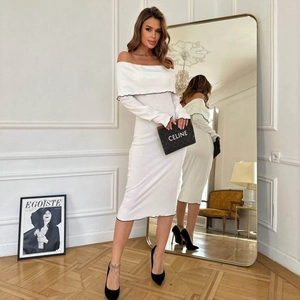 Detailed close-up of white off-the-shoulder knitted dress with black piping trim
