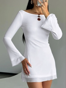 Detail of white boat neck mini dress featuring bell sleeves and sheer knit texture
