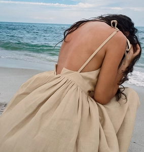 Detail der überkreuzten Träger und Schleife am beigen Leinenkleid im Strandstil