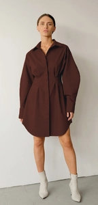Détails des plis à la taille et de l'ourlet arrondi d'une robe chemise marron