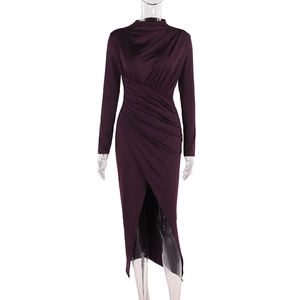 Detail view of the elegant ruching and asymmetric slit hem on a wine red midi dress