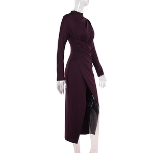 Detailed view of the elegant side ruching and slit hem on this deep purple midi dress