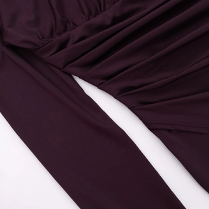 Detail of burgundy ruched fabric showing elegant pleated texture and silky material