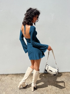 Detail of the backless tie-up design and bell sleeves on a navy mini dress