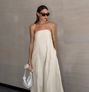 Detail of minimalist beige linen tube midi dress showing natural texture and clean cut