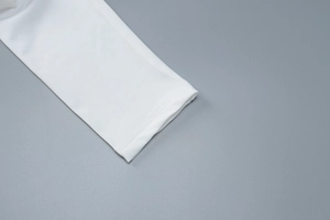 Close-up of double-stitched white long sleeve cuffs with high-quality needlework