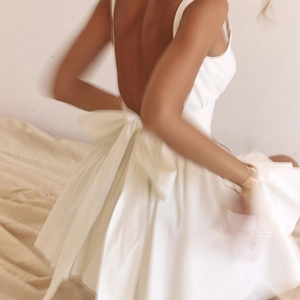 Détail de la robe blanche dos nu avec un grand nœud et une jupe en tulle multicouche