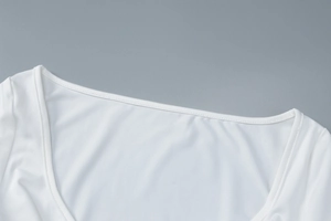 Close-up of white long sleeve V-neck top showing U-neckline and fine knitted texture