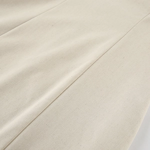 Macro detail of khaki cotton linen fabric showing natural fiber texture and fine stitching