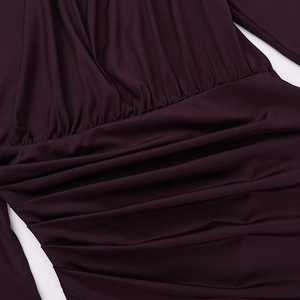 Detailed close-up of dark purple dress fabric with elegant ruching and gathered texture