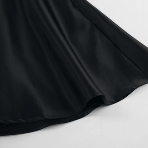 Close-up of black satin dress hem with smooth texture and high-quality edge stitching