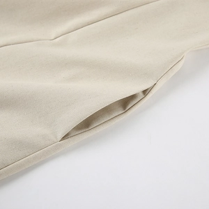 Detail view showing textured linen fabric and side pocket of the beige A-line dress