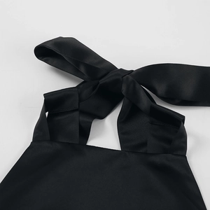 Detail of the black satin halter neck dress with a large elegant bow tie at the back