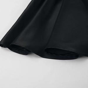 Detail of premium black satin fabric hem showing precise stitching and silky texture