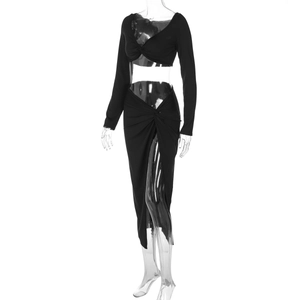 Detail of black two-piece set with long sleeve V-neck crop top and high slit skirt
