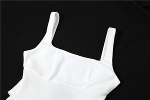 Gros plan d'une robe de soirée blanche avec encolure carrée et larges bretelles