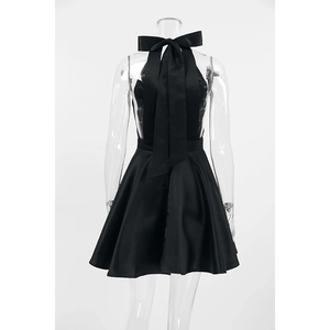 Detailed back view of a black satin halter dress featuring a large decorative bow