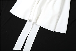 Détail de l'ourlet de robe blanche avec des lanières décoratives suspendues