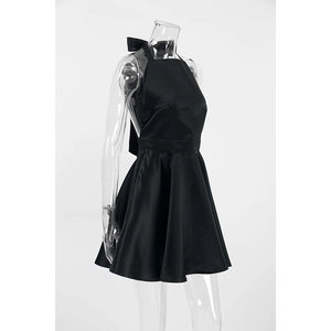 Detail of elegant black satin halter dress featuring a back cutout and silk bow detail