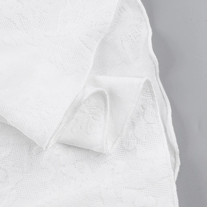 Close-up of white jacquard fabric texture and neat stitching on a backless summer dress