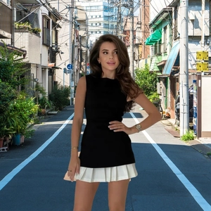 Détail du plissé contrasté sur robe noire sans manches avec élégant ourlet blanc