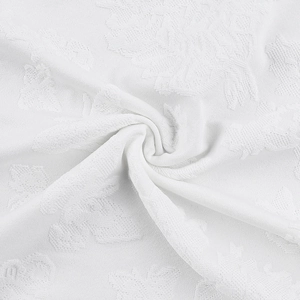 Close-up of white floral jacquard fabric texture with detailed leaf patterns