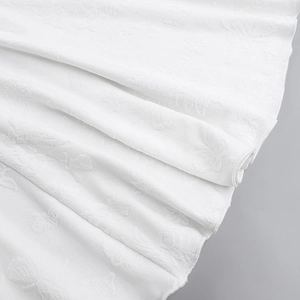 Detailed macro of white jacquard fabric with elegant butterfly patterns and pleats