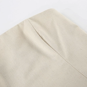 Detailed macro view showing natural cotton linen fabric texture and waist dart design