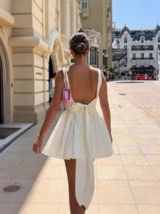 Robe courte blanche dos nu élégante avec grand nœud et jupe plissée évasée