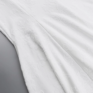 Detail of white dress fabric showing high-quality floral jacquard pattern and texture