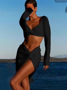 Women's black two-piece set with V-neck long sleeve crop top and high slit skirt