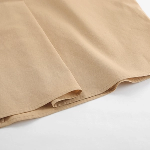 Detailansicht der natürlichen Leinentextur und Saumnaht am khakifarbenen Maxikleid