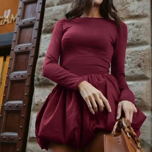 Detail of burgundy long sleeve bubble hem dress with elegant pleated volume skirt