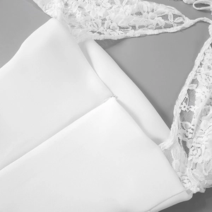 Detail eines weißen Spitzenkleides mit unsichtbarem Reißverschluss und floralen Trägern