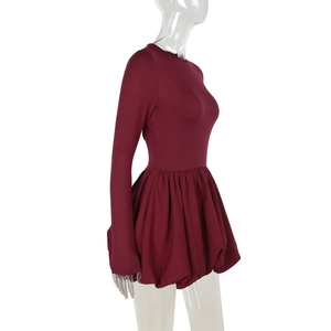 Detail of burgundy long sleeve dress featuring slim fit bodice and puff skirt silhouette