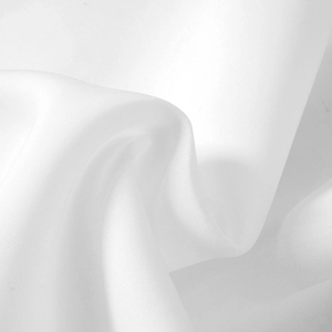 Detailaufnahme von weißem Spitzenstoff mit feiner Netzstruktur und elegantem Faltenwurf
