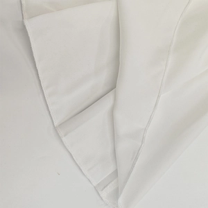 Gros plan détaillé montrant la texture du tissu blanc et les fines coutures de l'ourlet