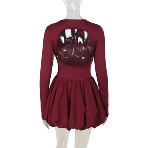Detail of burgundy backless mini dress featuring a circular cutout and bubble hemline