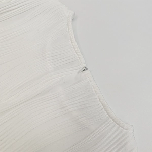 Détail du tissu en maille côtelée blanche avec fermeture éclair invisible et coutures nettes