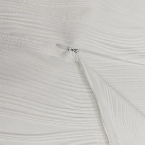 Gros plan détaillé du tissu texturé blanc ondulé et d'une fermeture éclair invisible