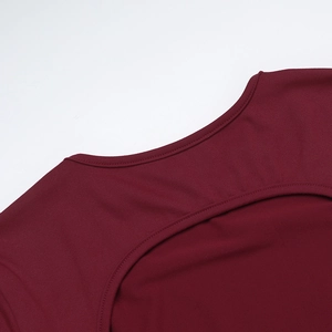 Detail of burgundy ribbed knit dress with round neck and crescent-shaped cutout feature