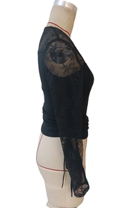 Detail view showing elegant floral lace sleeve and ruched side drawstring on black top