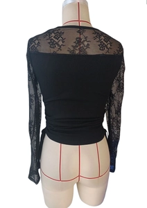 Macro view of floral lace sleeve stitching and sheer panel details on black top