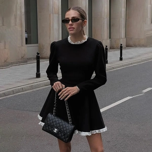 Détail de la bordure en dentelle blanche sur une robe noire rétro à manches longues