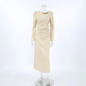 Detail view of the asymmetric neckline and ruched waist of this beige midi dress