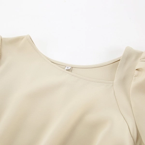 Detailed view of the khaki dress neckline featuring irregular collar and subtle pleated texture